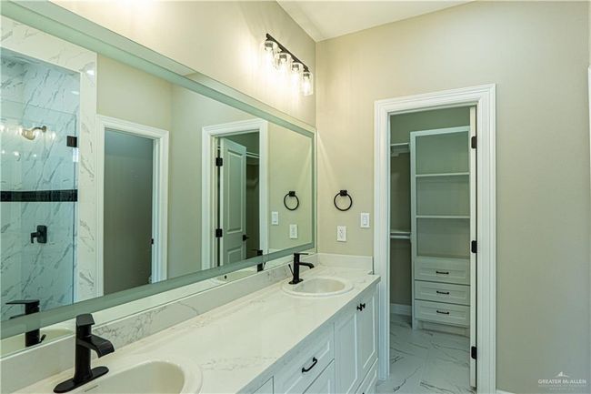 Bathroom with marble finish floor, a sink, a spacious closet, and a marble finish shower | Image 10