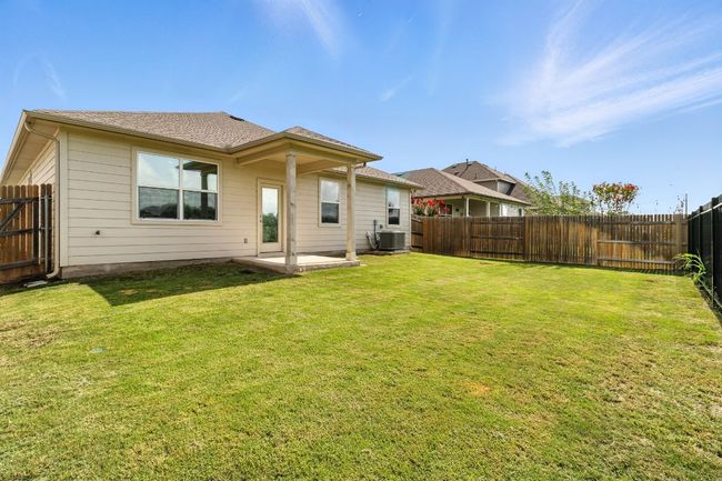 Back of property featuring a fenced backyard, a patio, and a shingled roof | Image 24