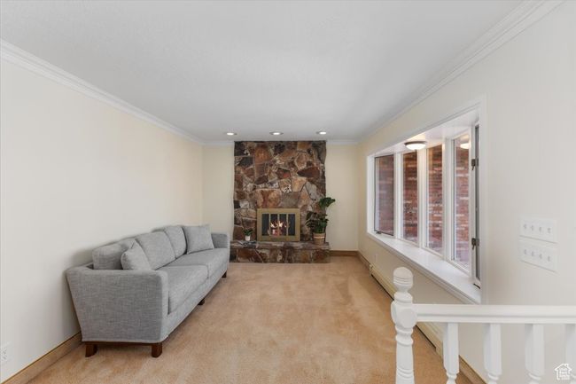 Living room with light carpet, a stone fireplace, and crown molding | Image 9