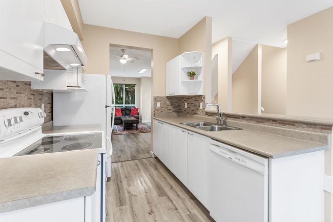 Kitchen featuring white cabinets, open shelves, white appliances, and a ceiling fan | Image 13