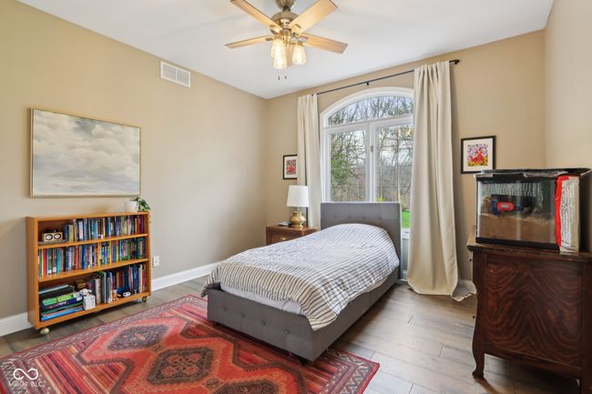 bedroom featuring wood finished floors, baseboards, ceiling fan, and visible vents | Image 39