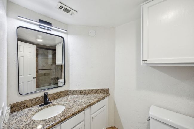 Full bath featuring toilet, vanity, and a shower | Image 11