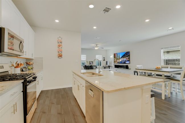 Kitchen with stainless steel appliances, a sink, healthy amount of natural light, light wood-type flooring, and recessed lighting | Image 9