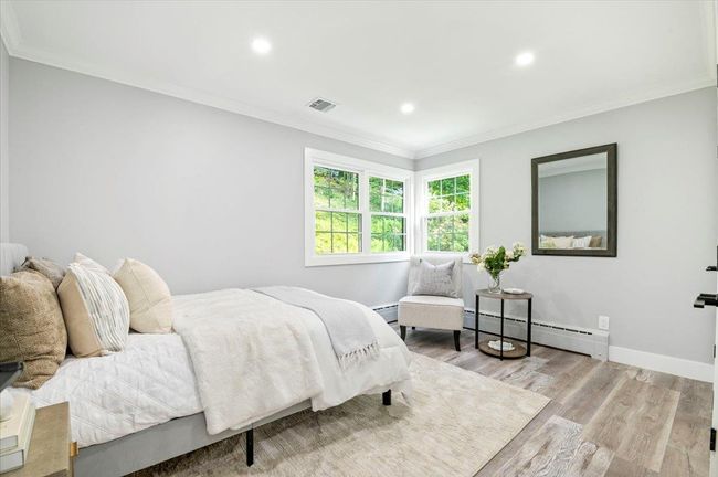 Bedroom featuring a baseboard radiator, crown molding, wood finished floors, and recessed lighting | Image 14