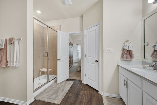 Full bathroom featuring a stall shower, wood finished floors, vanity, and baseboards | Image 17
