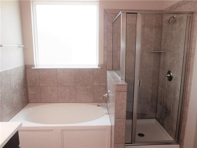 Bathroom featuring a garden tub, vanity, and a shower stall | Image 11