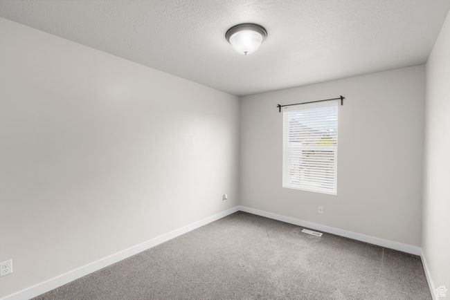 Carpeted spare room with a textured ceiling, visible vents, and baseboards | Image 22
