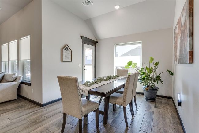 Dining room with baseboards, vaulted ceiling, visible vents, and light wood-style flooring | Image 28