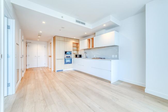 Kitchen with a sink, visible vents, appliances with stainless steel finishes, light wood finished floors, and modern cabinets | Image 7