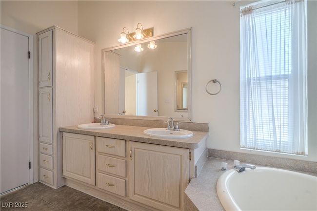 Full bathroom with double vanity, healthy amount of natural light, a bath, and tile patterned floors | Image 19