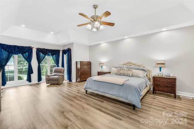 Primary Bedroom with a sitting area, two walk in closets and ensuite bath on the main level (virtually staged) | Image 11