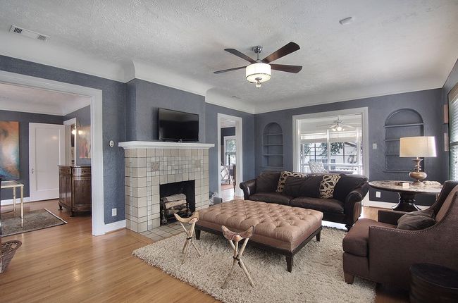 Living room with wood finished floors, built in features, ceiling fan, and visible vents | Image 23