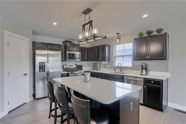 Custom cabinetry, sleek quartz countertops and modern backsplash make this space pop. | Image 30