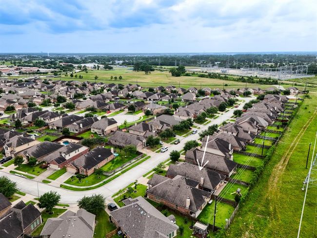 This wider aerial captures the home’s prime location within the community, nestled alongside the greenbelt—offering both peaceful natural views and easy access to neighborhood trails and open spaces. | Image 38