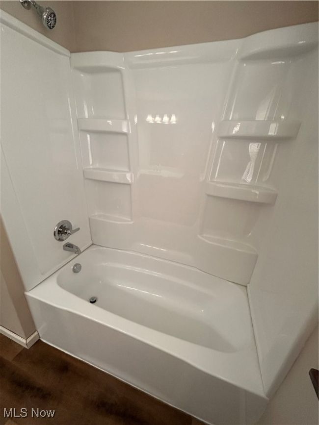 Full bathroom with shower / tub combination, wood finished floors, and baseboards | Image 13