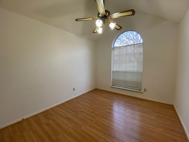 Unfurnished room with wood finished floors, lofted ceiling, and ceiling fan | Image 13