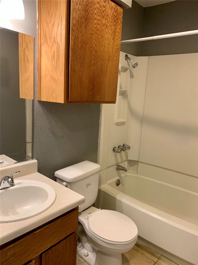 Full bath featuring toilet, vanity, a textured wall, and shower / bathing tub combination | Image 10