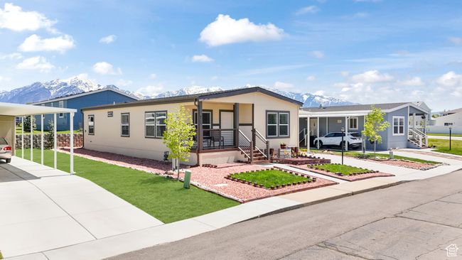 Manufactured / mobile home with concrete driveway, a carport, a front yard, a mountain view, and covered porch | Image 15