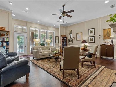 Living room featuring ceiling fan, dark wood-type flooring, and ornamental molding | Image 3