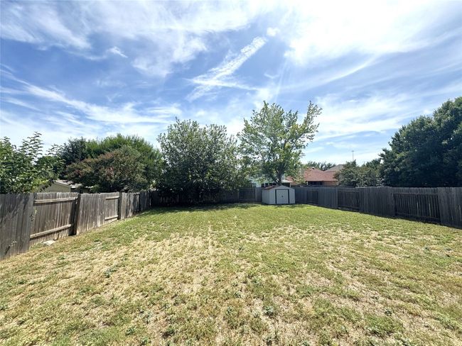 Fenced backyard featuring a shed | Image 16