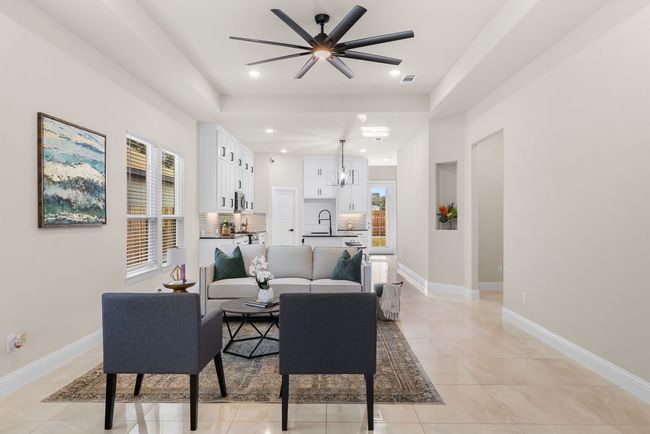 Living area with recessed lighting, light tile patterned floors, ceiling fan with notable chandelier, and baseboards | Image 13