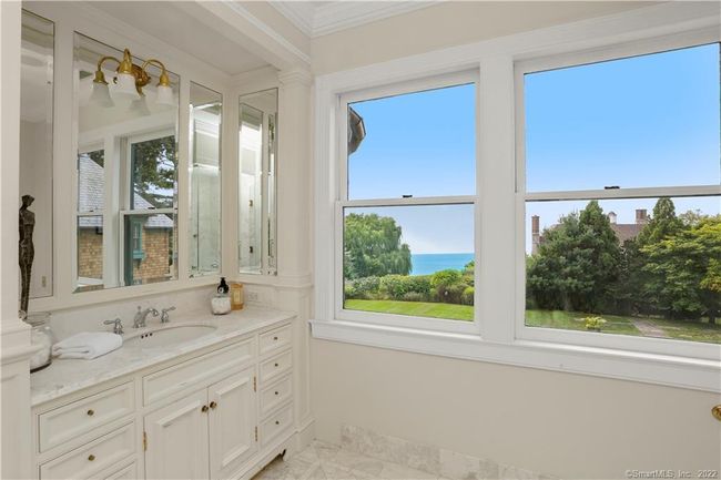 PRIMARY SUITE // The second full bath is outfitted with marble counters, flooring and shower. Waterworks fixtures compliment this stunning water view. | Image 21