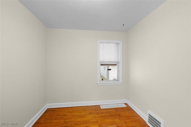 bedroom with wood finished floors, visible vents, and baseboards | Image 15