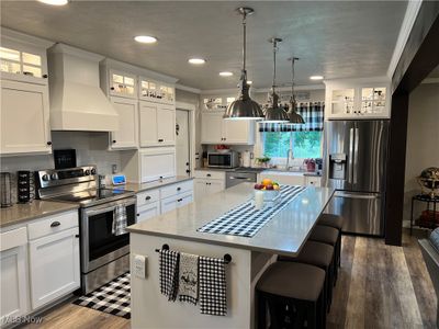 Kitchen featuring appliances with stainless steel finishes, ornamental molding, and premium range hood | Image 2