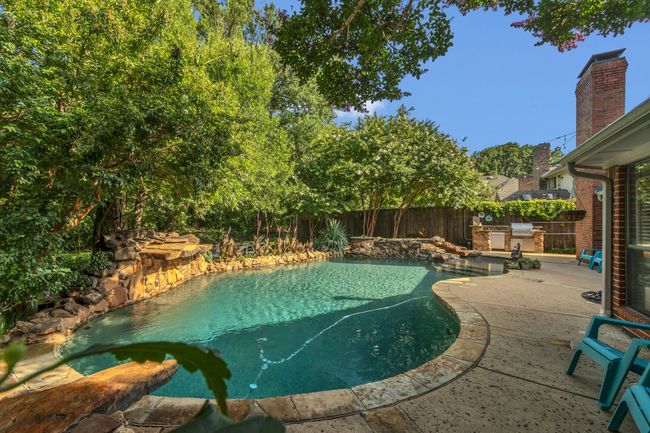 View of swimming pool with an outdoor kitchen, a fenced backyard, and a patio | Image 29