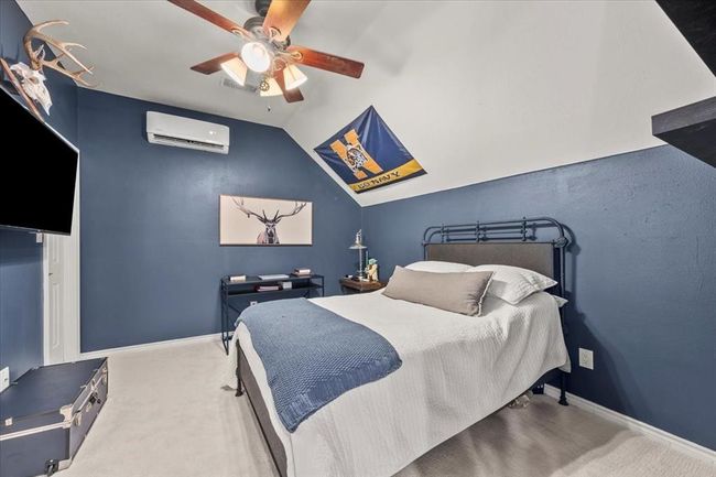 This secondary bedroom is currently styled as a sports-themed retreat with space for a bed, desk, and wall-mounted TV setup. | Image 33