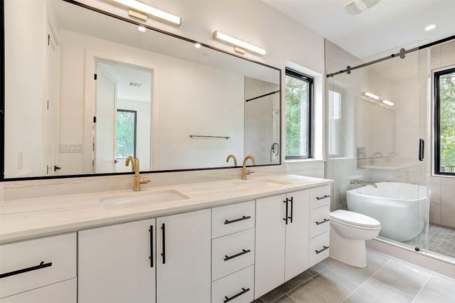 Bathroom with double vanity, a freestanding bath, tile patterned floors, and a shower stall | Image 8