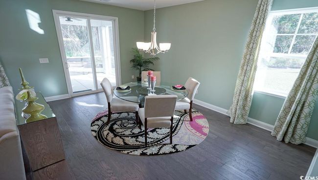 Dining area with a chandelier, wood finished floors, and baseboards | Image 14
