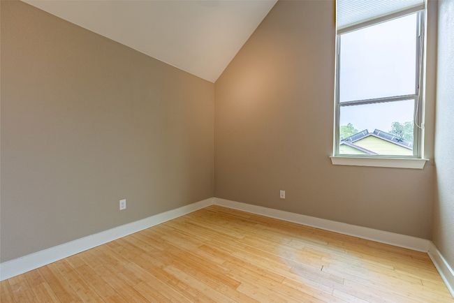 Empty room featuring wood finished floors and lofted ceiling | Image 6