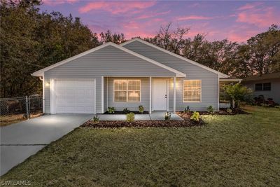 Single story home featuring a garage and a yard | Image 1