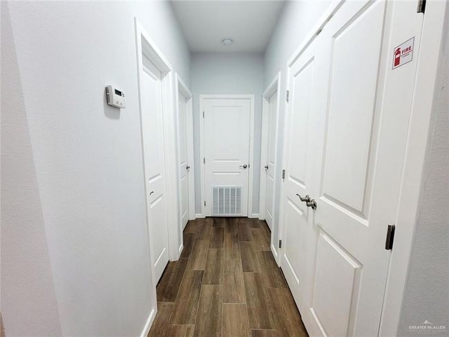 Hallway featuring visible vents, baseboards, and dark wood finished floors | Image 16