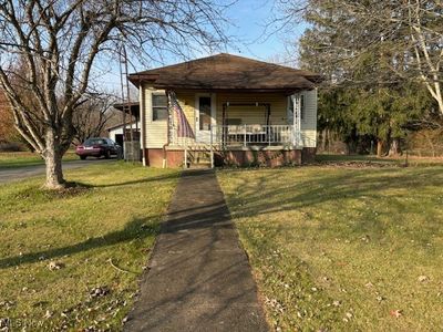 Bungalow-style home featuring a porch and a front yard | Image 1