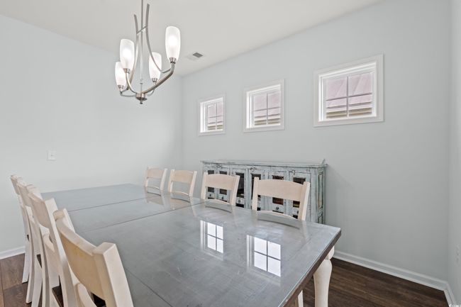 Dining area featuring many windows and an open concept. The upper deck is off of the dining area with pond view. | Image 20