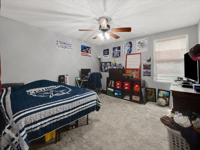 Bedroom featuring a textured ceiling, ceiling fan, and light carpet | Image 19