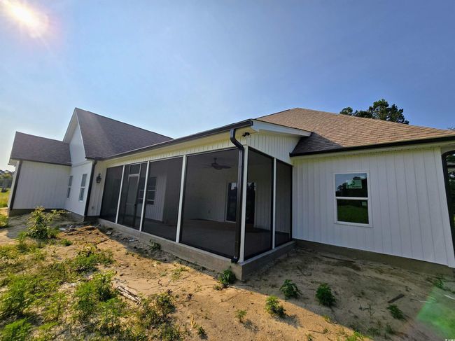 Rear view of house with a sunroom, roof with shingles, and a ceiling fan | Image 33