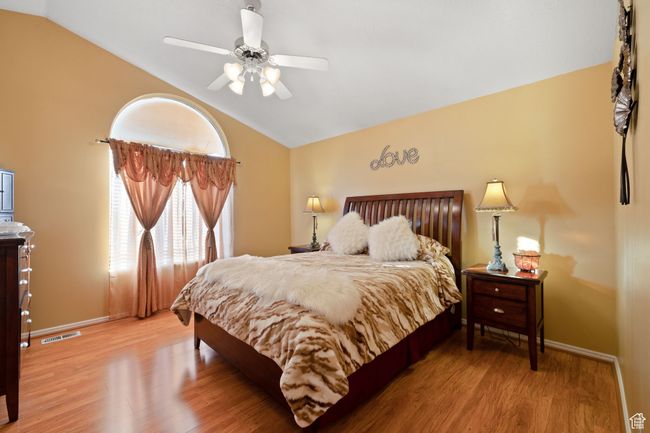 Bedroom featuring lofted ceiling, wood-type flooring, and ceiling fan | Image 16