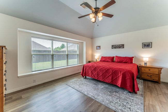 Bedroom with vaulted ceiling, wood finished floors, baseboards, and ceiling fan | Image 11