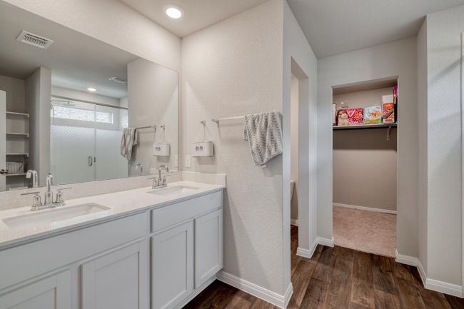 Full bathroom with a spacious walk in shower, double vanity, a walk in closet, and baseboards | Image 18