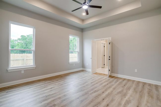 Spare room with baseboards, ceiling fan, light wood-type flooring, recessed lighting, and a raised ceiling | Image 29