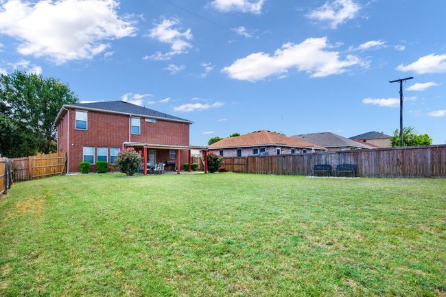 Fenced backyard with a patio | Image 21