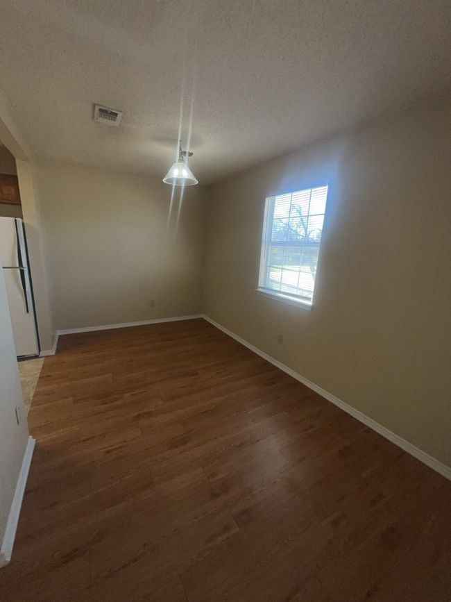 Unfurnished dining area with baseboards, visible vents, a textured ceiling, and wood finished floors | Image 12