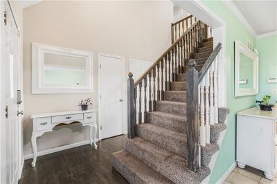 Stairs featuring hardwood / wood-style flooring and ornamental molding | Image 3