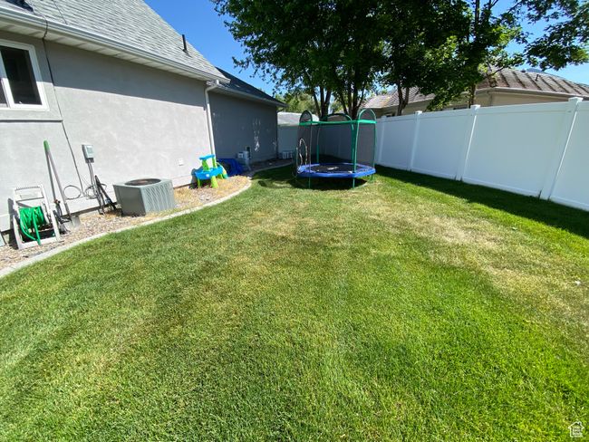 View of yard with a trampoline and cooling unit | Image 25