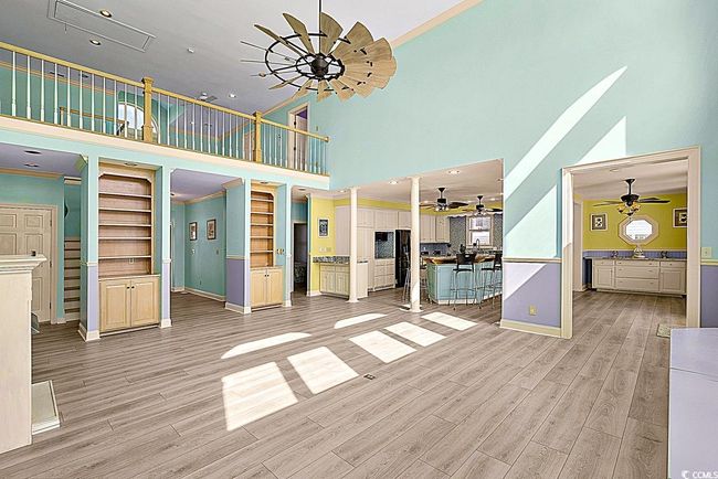 Unfurnished living room with light wood-style floors, crown molding, stairway, and baseboards | Image 11