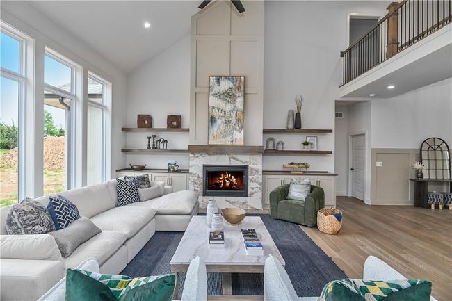Living room featuring a high end fireplace, high vaulted ceiling, and hardwood / wood-style flooring | Image 9
