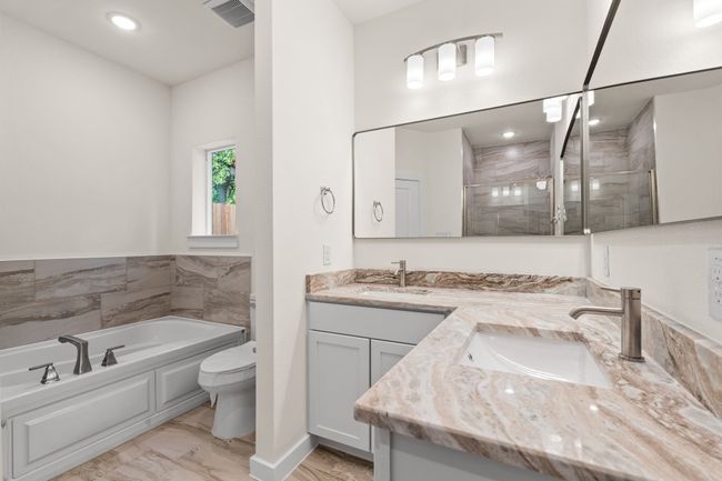 Full bathroom with double vanity, a bath, a shower stall, toilet, and recessed lighting | Image 22